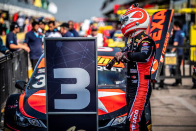 Clickable image of a driver and car in the pit lane of a motorsport event